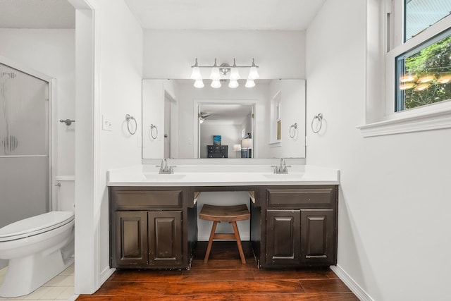 149 Kel Wen Cir, Destin, FL 32541 - full bath with double vanity, a shower stall, toilet, ceiling fan, and wood finished floors
