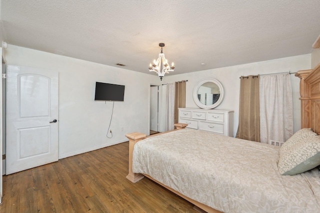 124 Palmetto Dr, Crestview, FL 32539 - bedroom with a chandelier, wood finished floors, baseboards, and a textured ceiling