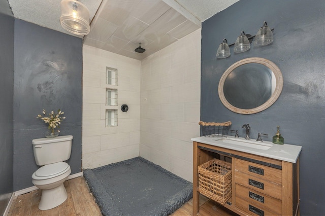 124 Palmetto Dr, Crestview, FL 32539 - bathroom with wood finished floors, toilet, vanity, and tiled shower