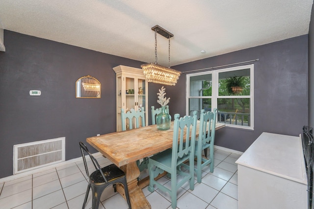 124 Palmetto Dr, Crestview, FL 32539 - dining area with a chandelier, light tile patterned floors, a textured ceiling, and baseboards