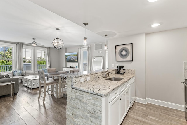 9500 Grand Sandestin Blvd Unit 2325, Miramar Beach, FL 32550 - kitchen with a sink, light wood finished floors, white cabinets, baseboards, and ceiling fan
