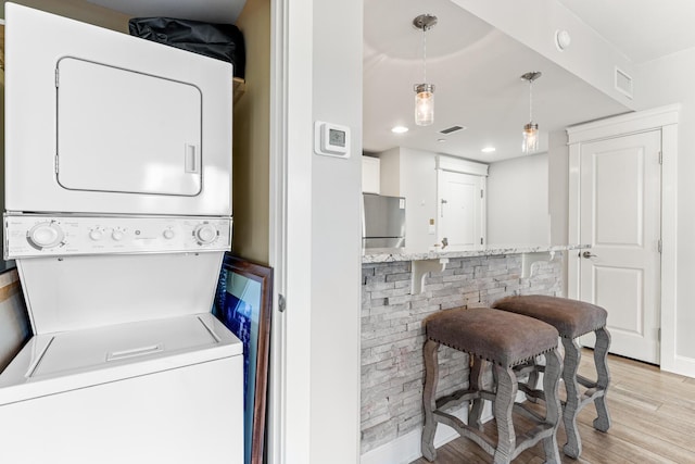 9500 Grand Sandestin Blvd Unit 2325, Miramar Beach, FL 32550 - clothes washing area with estacked washer and dryer, light wood-style floors, and recessed lighting
