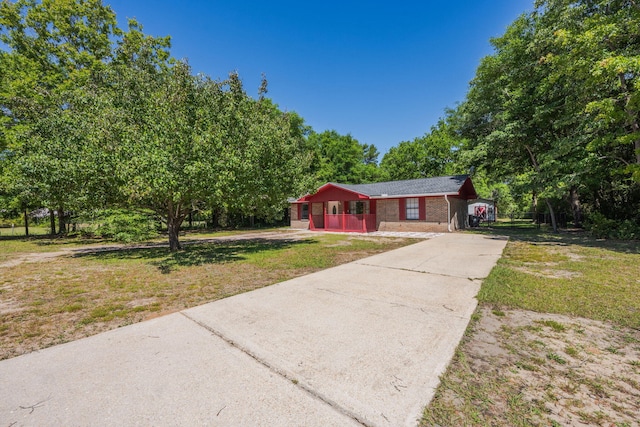 205 Florence Dr, Defuniak Springs, FL 32433 - ranch-style house with covered porch, driveway, a front lawn, and brick siding