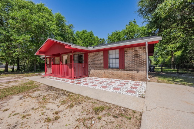 205 Florence Dr, Defuniak Springs, FL 32433 - view of front facade with brick siding, a porch, and fence