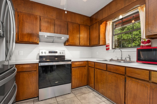 205 Florence Dr, Defuniak Springs, FL 32433 - kitchen featuring appliances with stainless steel finishes, under cabinet range hood, a sink, light countertops, and a textured ceiling