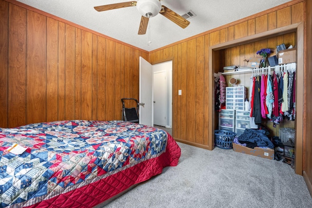 205 Florence Dr, Defuniak Springs, FL 32433 - carpeted bedroom featuring a closet, wooden walls, a textured ceiling, and a ceiling fan