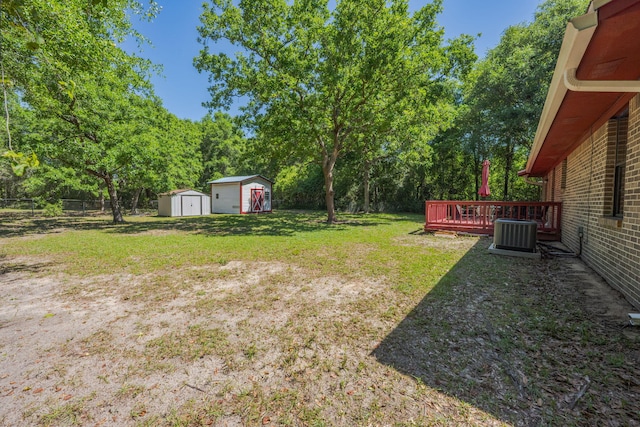 205 Florence Dr, Defuniak Springs, FL 32433 - view of yard featuring a storage unit, cooling unit, an outdoor structure, a wooden deck, and view of wooded area