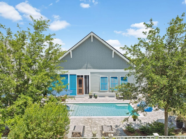 rear view of house with an outdoor pool and a patio area
