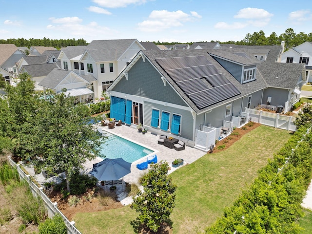 rear view of house with a patio, a residential view, an outdoor living space, solar panels, and outdoor dining area