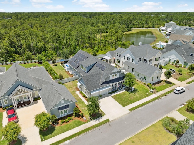 aerial view of residential area with a heavily wooded area and a large body of water