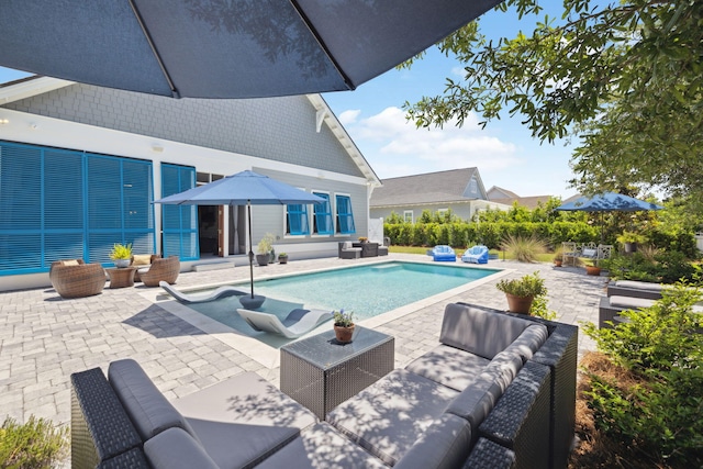 swimming pool with an outdoor living space and a patio