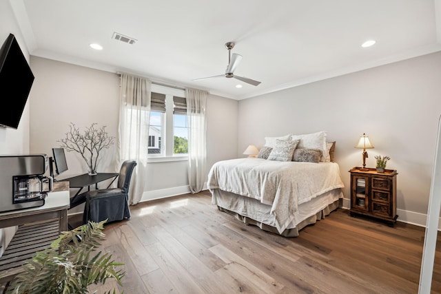 bedroom featuring wood finished floors, crown molding, baseboards, recessed lighting, and ceiling fan
