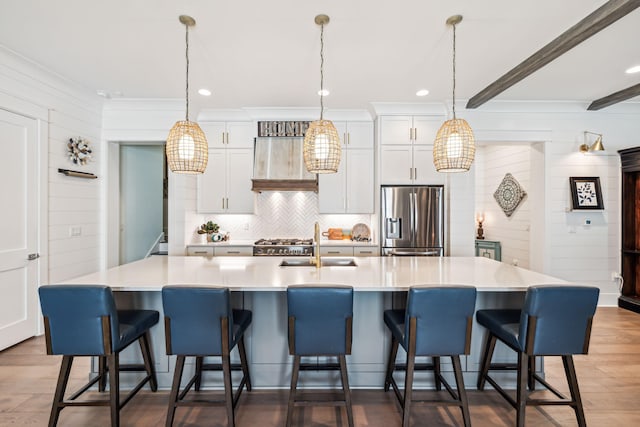 kitchen with stainless steel fridge, a sink, wood finished floors, light countertops, and recessed lighting