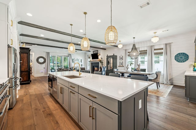 kitchen featuring gray cabinets, a sink, stainless steel appliances, dark wood-style flooring, and recessed lighting