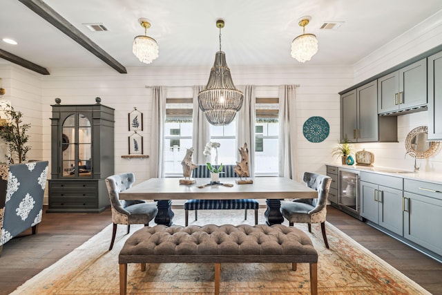 dining area with a chandelier, dark wood-style floors, beamed ceiling, wine cooler, and wooden walls