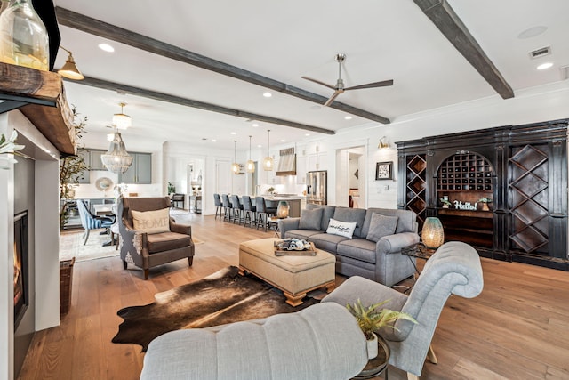 living room featuring beam ceiling, ceiling fan, light wood-style floors, and recessed lighting