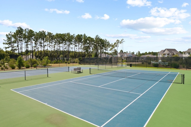 view of tennis court featuring community basketball court and fence