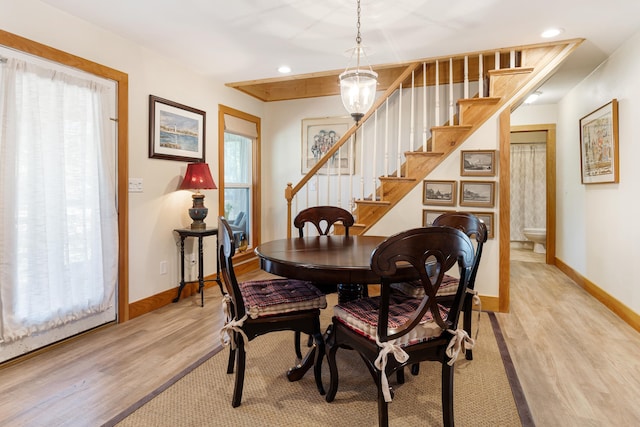 dining space featuring light wood-style flooring, baseboards, stairs, and recessed lighting