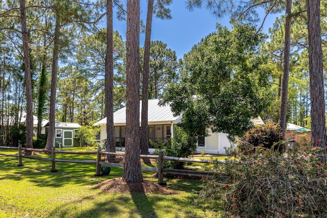 view of front of house featuring metal roof, an outdoor structure, and a storage shed
