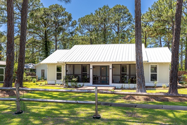 view of front of property with a front lawn, a sunroom, and metal roof
