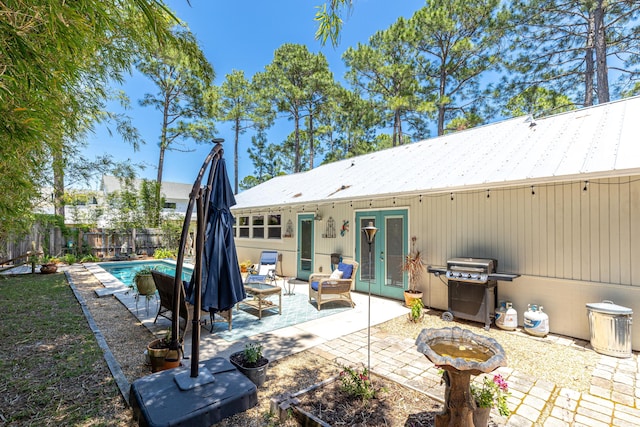 rear view of house featuring a patio area, a fenced backyard, and french doors