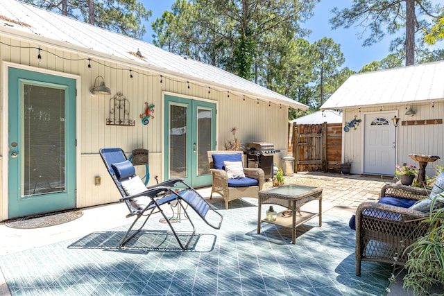 view of patio with french doors, grilling area, a gate, and fence