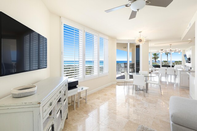 15400 Emerald Coast Pkwy Unit 301, Destin, FL 32541 - living room featuring a ceiling fan, a chandelier, baseboards, and light marble finish flooring