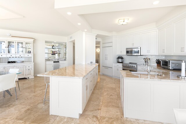 15400 Emerald Coast Pkwy Unit 301, Destin, FL 32541 - kitchen featuring stainless steel appliances, light stone countertops, tasteful backsplash, a peninsula, and recessed lighting