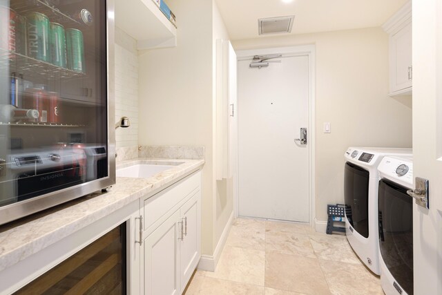 15400 Emerald Coast Pkwy Unit 301, Destin, FL 32541 - laundry area featuring separate washer and dryer, wine cooler, cabinet space, and baseboards