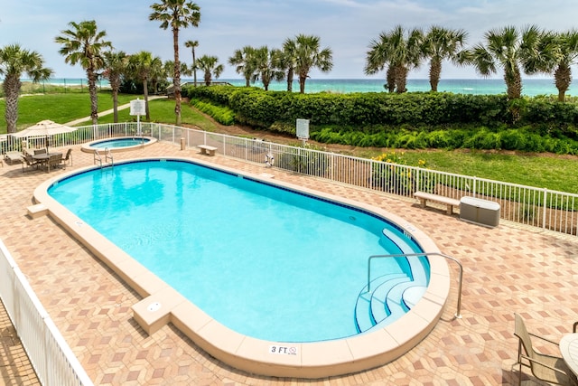 15400 Emerald Coast Pkwy Unit 301, Destin, FL 32541 - community pool featuring a community hot tub, fence, a water view, and a patio area