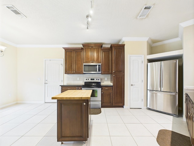 5261 Moore Loop, Crestview, FL 32536 - kitchen featuring stainless steel appliances, butcher block countertops, ornamental molding, decorative backsplash, and light tile patterned floors