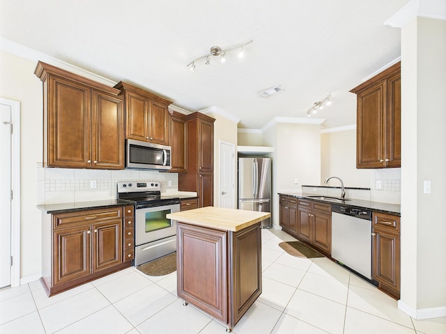 5261 Moore Loop, Crestview, FL 32536 - kitchen with stainless steel appliances, crown molding, backsplash, a center island, and light tile patterned flooring