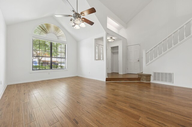 1405 Ariel Ln, Fort Walton Beach, FL 32547 - unfurnished living room featuring ceiling fan, wood finished floors, baseboards, high vaulted ceiling, and stairway
