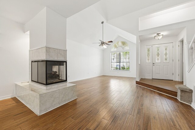 1405 Ariel Ln, Fort Walton Beach, FL 32547 - unfurnished living room with wood-type flooring, ceiling fan, a fireplace, vaulted ceiling, and baseboards