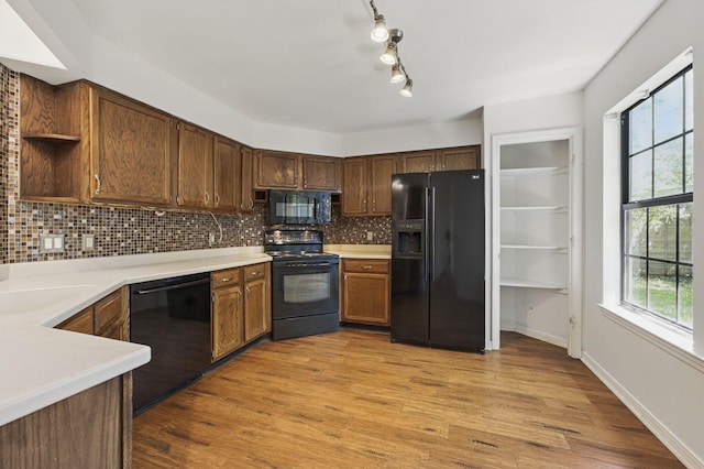 1405 Ariel Ln, Fort Walton Beach, FL 32547 - kitchen featuring black appliances, decorative backsplash, light countertops, light wood-style floors, and open shelves