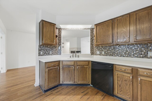1405 Ariel Ln, Fort Walton Beach, FL 32547 - kitchen featuring dishwasher, a sink, decorative backsplash, dark wood-type flooring, and light countertops