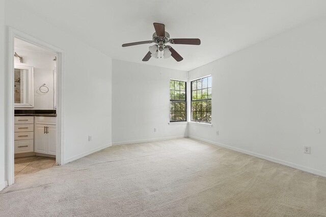 1405 Ariel Ln, Fort Walton Beach, FL 32547 - unfurnished bedroom with light colored carpet, baseboards, connected bathroom, and a ceiling fan