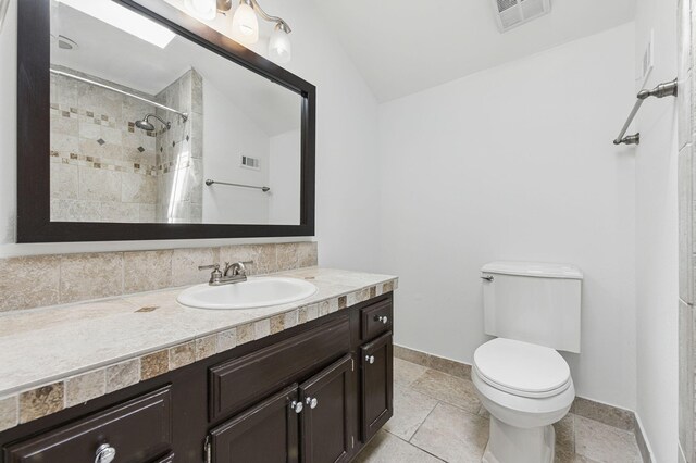 1405 Ariel Ln, Fort Walton Beach, FL 32547 - full bath featuring toilet, vanity, a tile shower, baseboards, and lofted ceiling