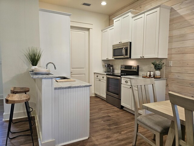 10 Gulfview Way, Santa Rosa Beach, FL 32459 - kitchen with appliances with stainless steel finishes, a sink, dark wood-style floors, a kitchen breakfast bar, and backsplash
