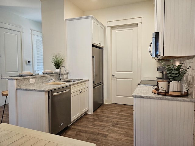 10 Gulfview Way, Santa Rosa Beach, FL 32459 - kitchen with appliances with stainless steel finishes, a sink, dark wood-style flooring, a peninsula, and white cabinets