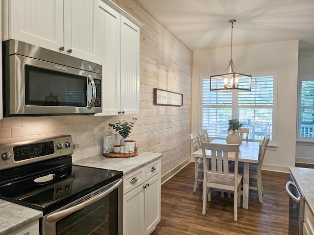 10 Gulfview Way, Santa Rosa Beach, FL 32459 - kitchen featuring stainless steel appliances, a chandelier, wooden walls, light countertops, and white cabinetry