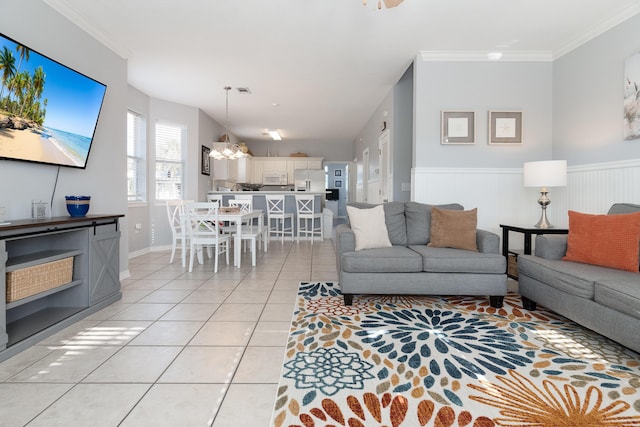 77 Mark St, Destin, FL 32541 - living room with light tile patterned floors, wainscoting, a chandelier, and ornamental molding