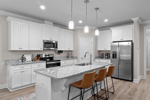 5414 Harmony Ln, Gulf Breeze, FL 32563 - kitchen featuring appliances with stainless steel finishes, a sink, ornamental molding, white cabinetry, and a kitchen island with sink