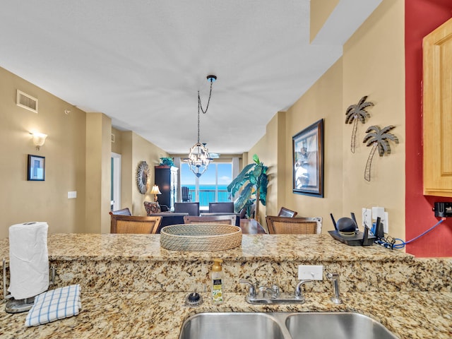 14825 Front Beach Rd Unit 1904, Panama City Beach, FL 32413 - kitchen with a sink, a chandelier, light stone counters, and pendant lighting