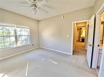 1501 N Partin Dr Unit 216, Niceville, FL 32578 - unfurnished bedroom with light colored carpet, baseboards, and a ceiling fan