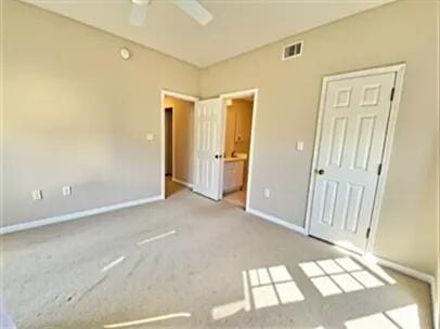 1501 N Partin Dr Unit 216, Niceville, FL 32578 - unfurnished bedroom with carpet flooring, baseboards, connected bathroom, and ceiling fan
