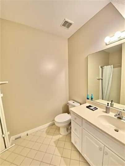 1501 N Partin Dr Unit 216, Niceville, FL 32578 - full bath with toilet, vanity, tile patterned flooring, a shower with curtain, and baseboards