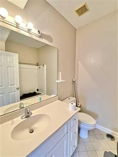 1501 N Partin Dr Unit 216, Niceville, FL 32578 - full bathroom with tile patterned flooring, toilet, vanity, baseboards, and a shower