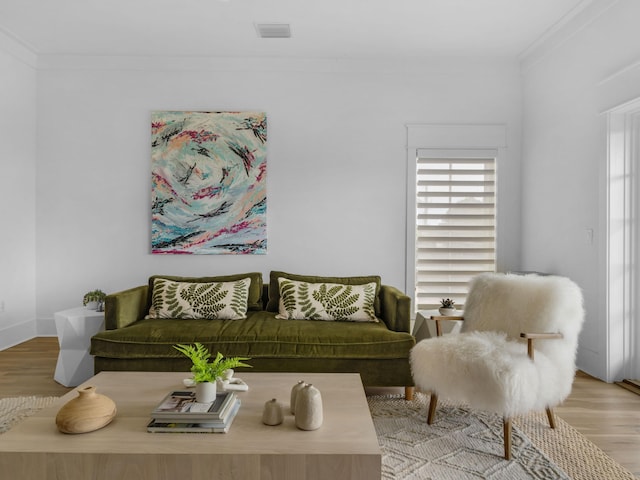 living room with crown molding, light wood finished floors, and baseboards