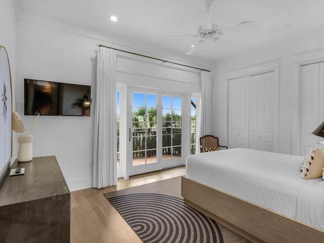 bedroom with access to exterior, wood finished floors, recessed lighting, ceiling fan, and two closets